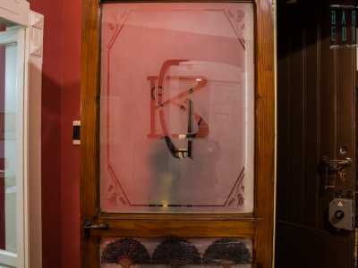 ...e le porte in legno e vetro dell'epoca, su cui � ben visibile un monogramma con le iniziali del primo proprietario
